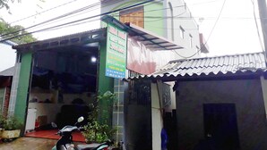 A guest house with a sign advertising Wifi Coffee Live and a motorcycle parked outside.