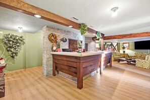 Uma sala de estar ampla com um balcão de madeira, lareira de pedra e um aconchegante espaço para sentar.