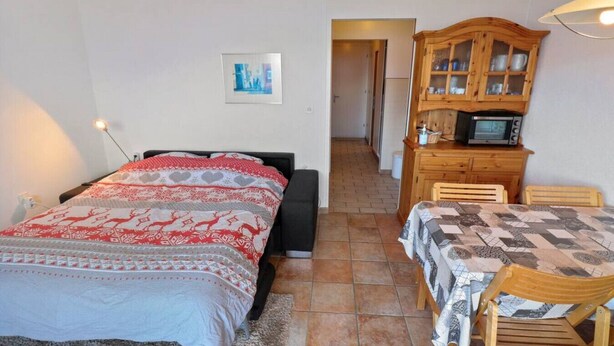 Un dormitorio con una cama, un escritorio y una silla.