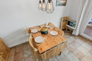 A wooden dining table set with plates, cutlery, and a coffee maker. - Marigny 65 - Beautiful view, ideal for skiing, quiet location (Crans-Montana)