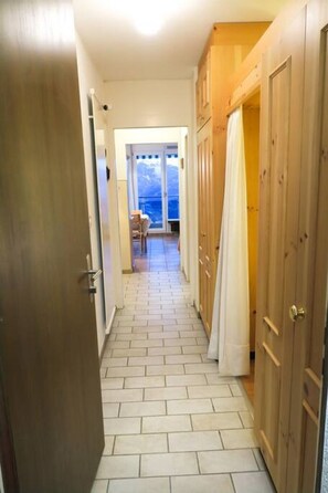 Een hal met betegelde vloer die leidt naar een kamer met uitzicht op zee.