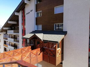 Ein modernes Gebäude mit Holzfassade und roter Markise.