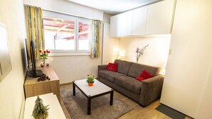 Un salon confortable avec un canapé, une table basse et une petite plante.
