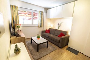 Un salon confortable avec un canapé, une table basse et une petite plante.