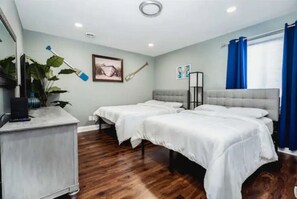 A hotel room with two beds, a desk, a plant, and a painting on the wall. - Lakefront Penthouse Fully Upgraded Panoramic Views Boat Slip Indoor Outdoor Pool (Wisconsin Dells)