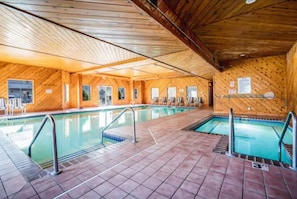 An indoor swimming pool with wooden walls and tiled flooring.