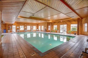 Relax by the pool surrounded by lush greenery and comfortable lounge chairs.