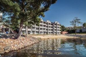 Un hôtel à plusieurs étages doté de balcons, d’une piscine et d’une côte rocheuse.