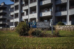 Un edificio residencial de varios pisos con balcones y un letrero que indica que es un conjunto de condominios llamado Lighthouse Cove.