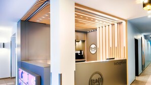 A reception area with a modern design, including a reception desk and a sign for B&B Hotels. - B&B Hotel Bochum-City (Bochum)