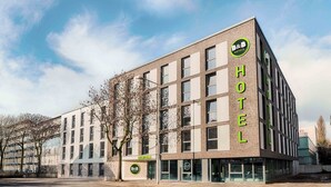 A modern hotel building with a prominent B&B logo, multiple windows, and a reception area. - B&B Hotel Bochum-City (Bochum)