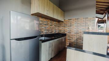 Habitación doble Deluxe, vista a la alberca | Cocina compartida | Refrigerador con congelador, microondas y utensilios de cocina