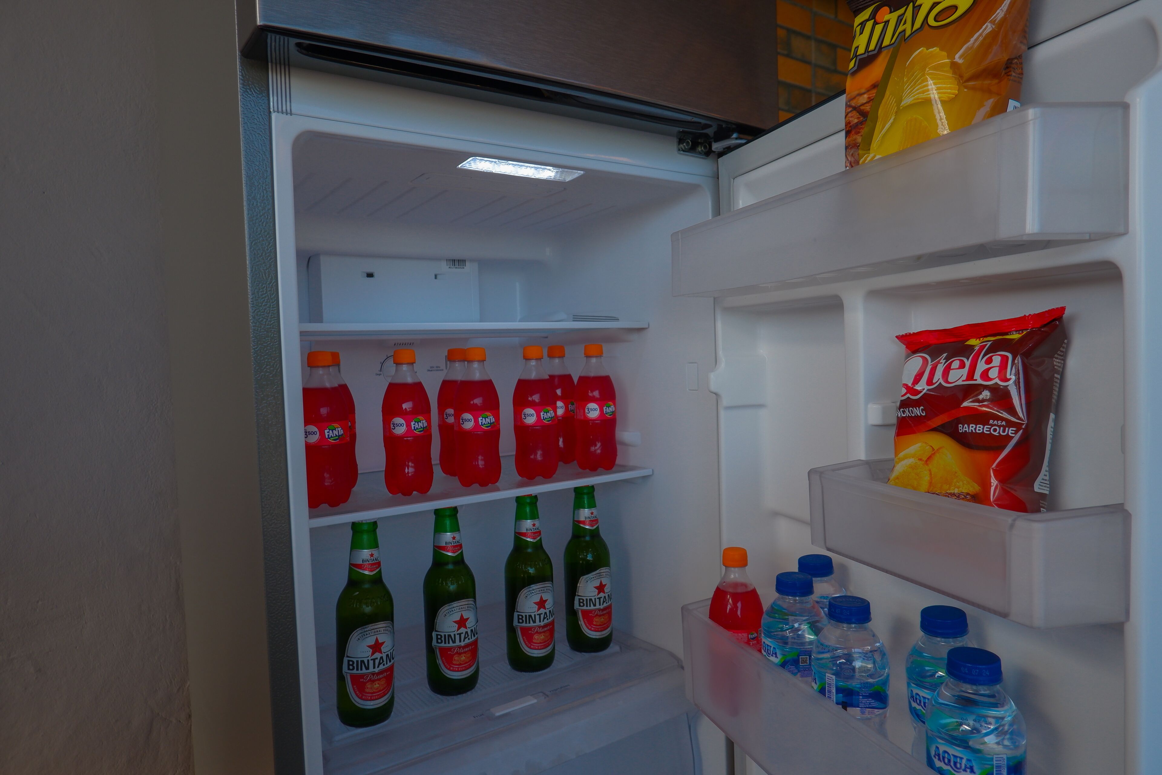 Un frigorífic ple de begudes, com ara Fanta, Bintang i aigua Aquafina.
