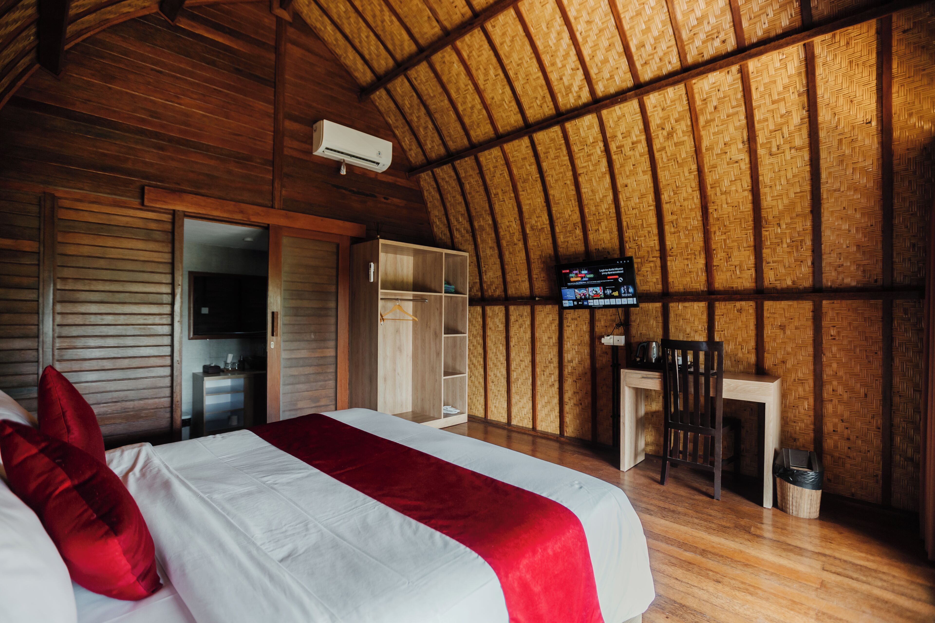A room with a bed, a desk, a chair, and a television.