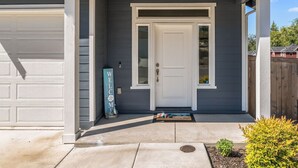 A residential house with a front porch, a garage door, and a welcome sign. - Impeccable 4 BR Home in Heart of Port Orchard (Port Orchard)