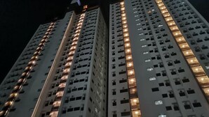 A high-rise building with multiple floors, each illuminated by warm interior lighting. - Enjoy the luxury and comfort of living (Cebu)