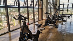 A gym with stationary bikes and large windows offering a city view. - Enjoy the luxury and comfort of living (Cebu)