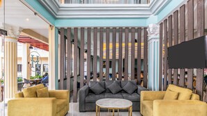 A modern lobby with a grey sofa, two yellow armchairs, and a marble coffee table. - Hotel Horizon Entebbe (Entebbe)