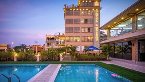 A hotel with a swimming pool, outdoor seating, and a well-lit facade. - Hotel Horizon Entebbe (Entebbe)