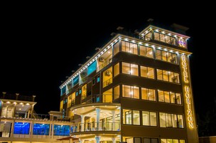 Un hotel de varios pisos con balcones y ventanas amplias, con el nombre "HOTEL HORIZON" en la fachada.