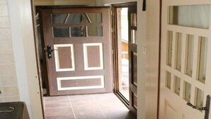 A hallway with a wooden floor leading to a door with frosted glass panels. - Tradicionalna Zagorska Drvena Kuća Stara Murva (Tuhelj)