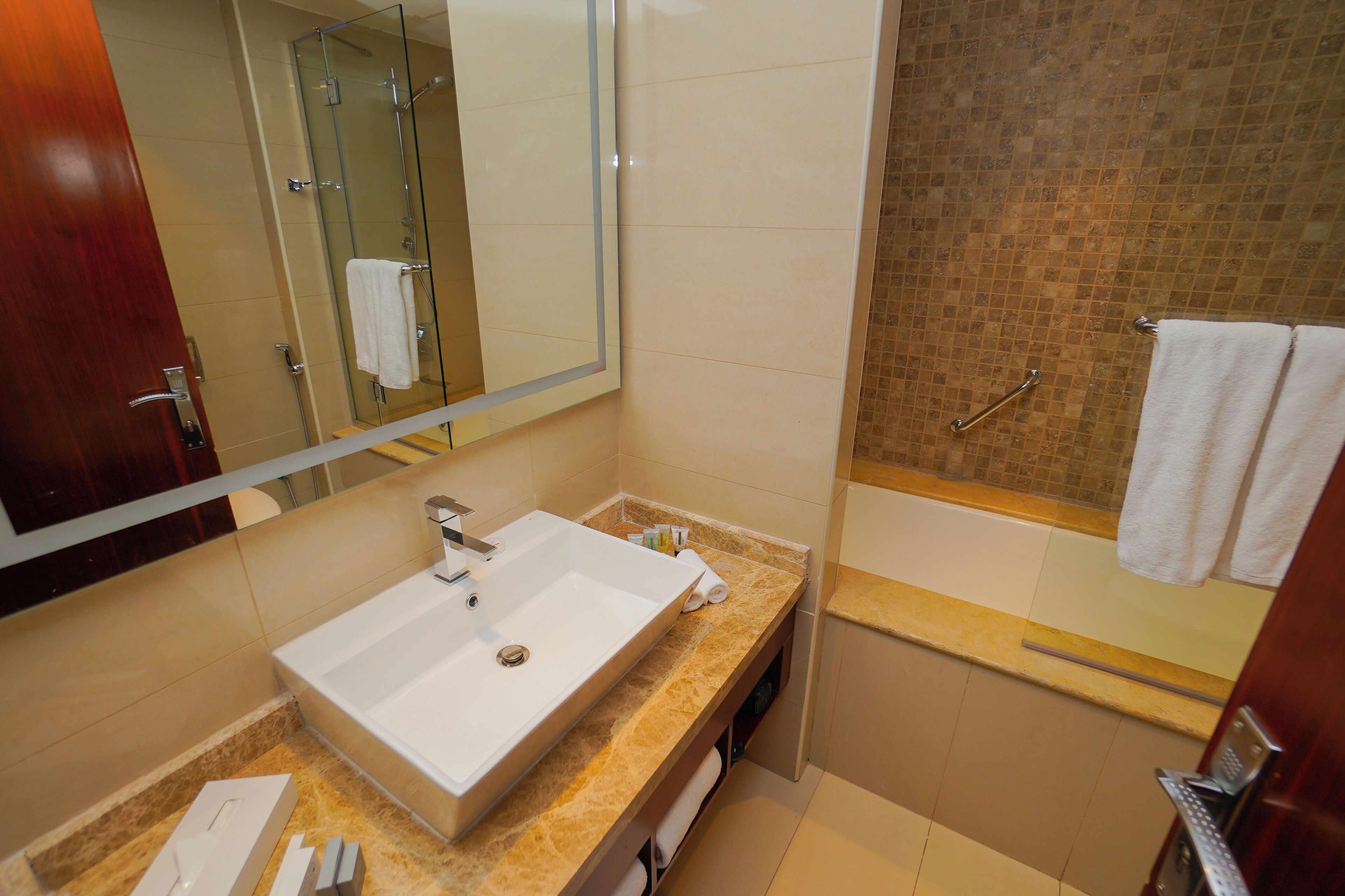 A modern bathroom with a large sink, a glass shower enclosure, and a bathtub.