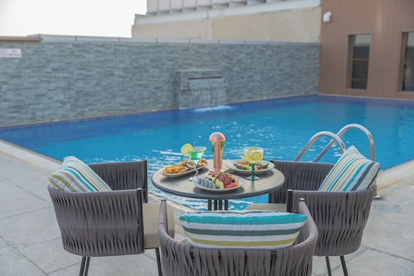Outdoor pool, pool loungers, lifeguards on site