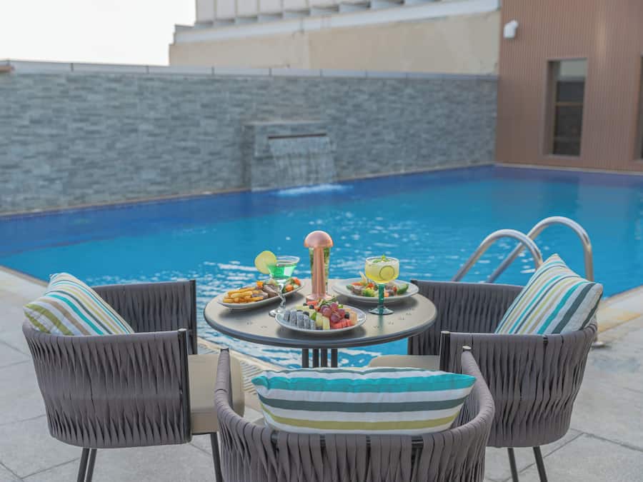 Una piscina al aire libre, sillones reclinables de piscina