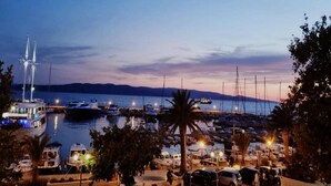 A marina at dusk with boats docked and a prominent sailboat in the background. - Lux Apartment Mare By the Sea & Beach (Baska Voda)