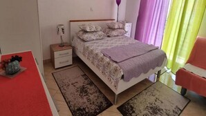 A bedroom with a bed, nightstands, a desk, a chair, and a painting on the wall. - Lux Apartment Mare By the Sea & Beach (Baska Voda)