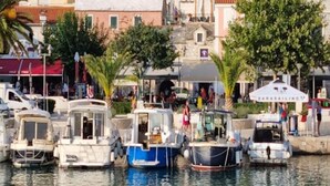 A coastal village with boats docked along the waterfront, surrounded by residential buildings and greenery. - Lux Apartment Mare By the Sea & Beach (Baska Voda)
