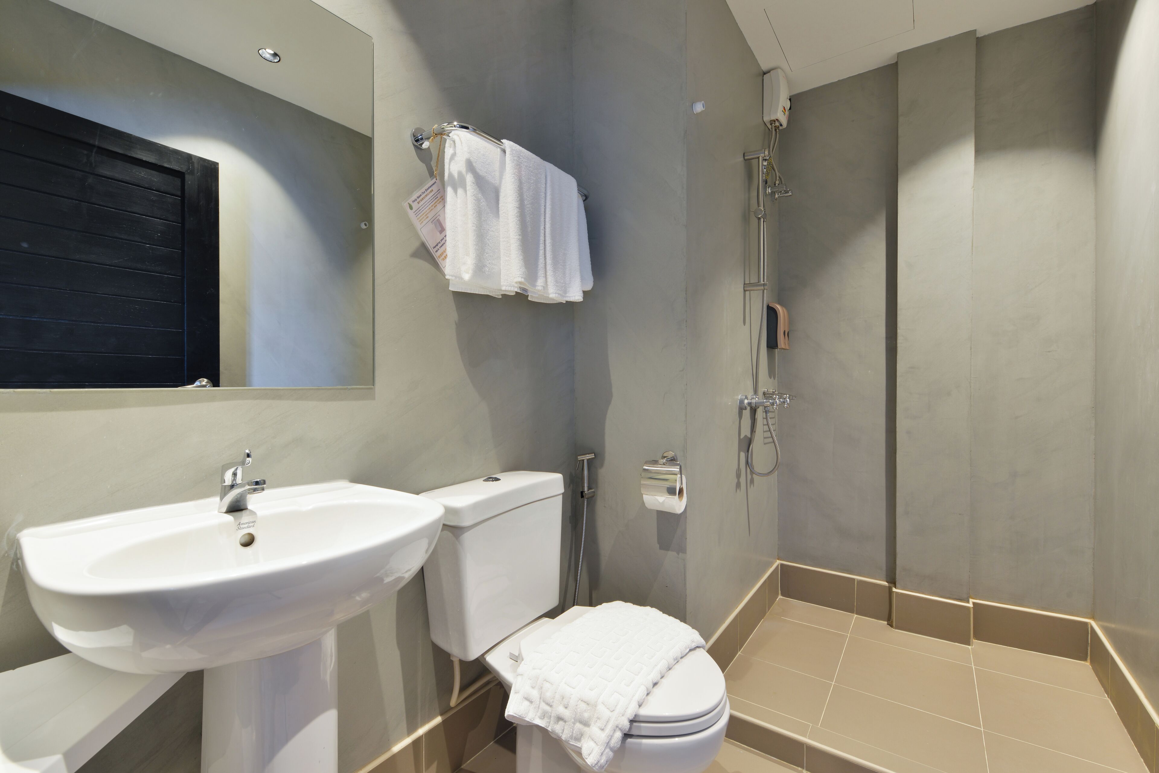 A modern bathroom with a sink, toilet, and shower.
