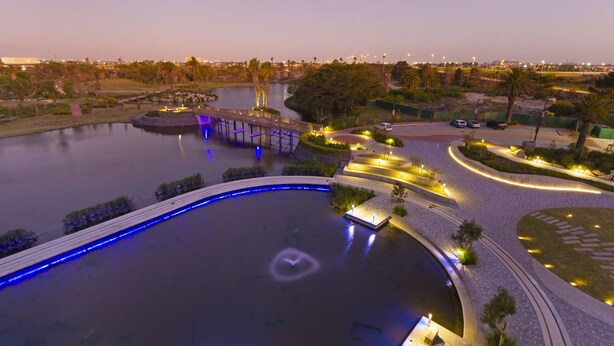 A landscaped area with a water feature, pathways, and a bridge. - Bridgewater View 502 (Cape Town)