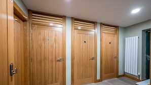 Un couloir avec des portes en bois et un radiateur.
