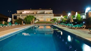 A swimming pool with lounge chairs and a building in the background. - Hotel Alhaurín Golf Resort (Alhaurin el Grande)