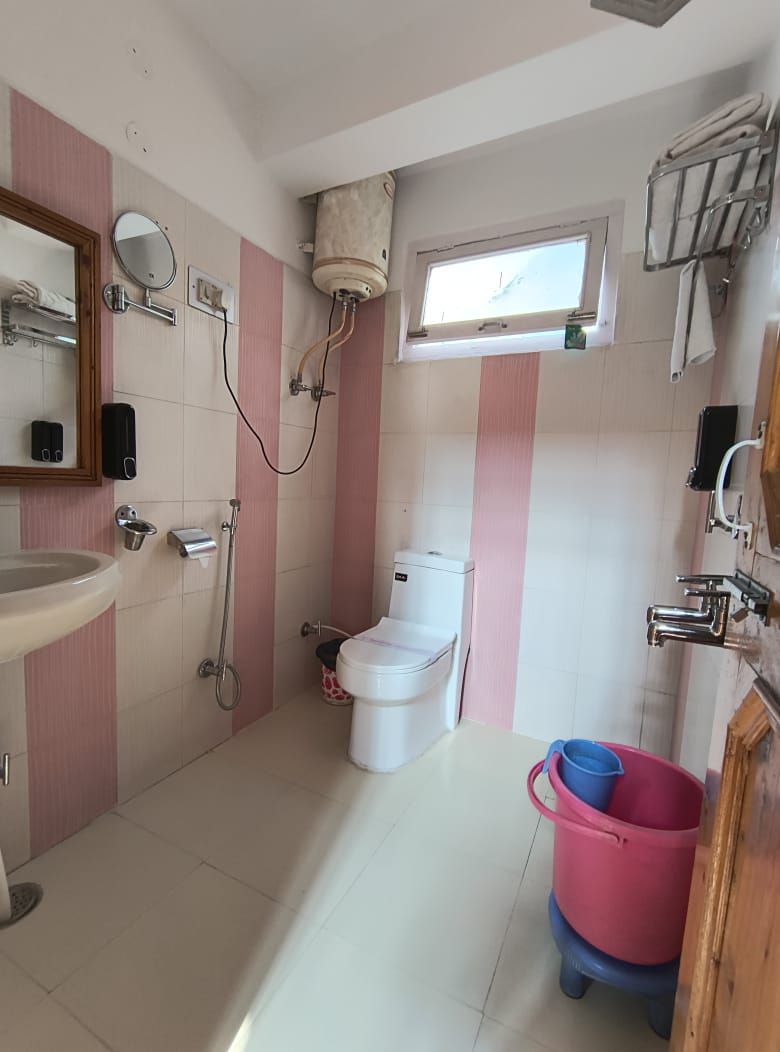 Une salle de bain avec des toilettes, un lavabo et une fenêtre.