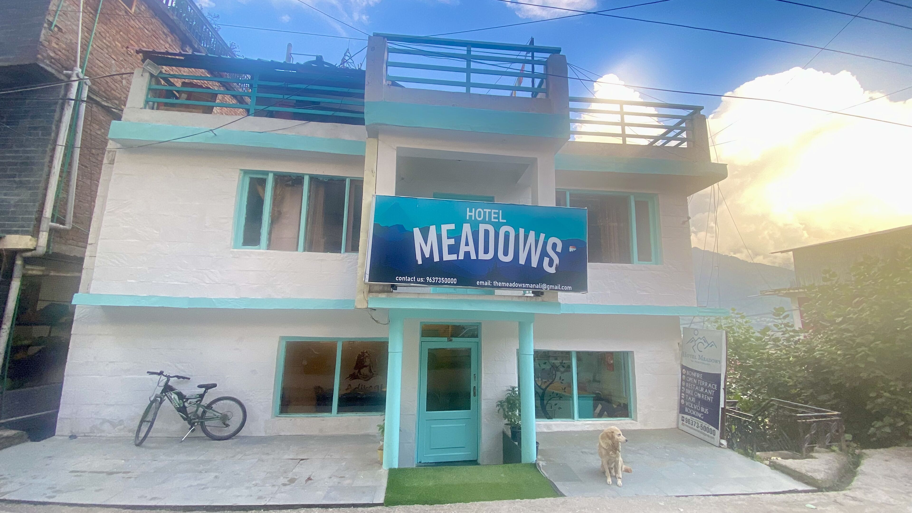 Un edificio de dos pisos con un letrero que dice 'Hotel Meadows'.