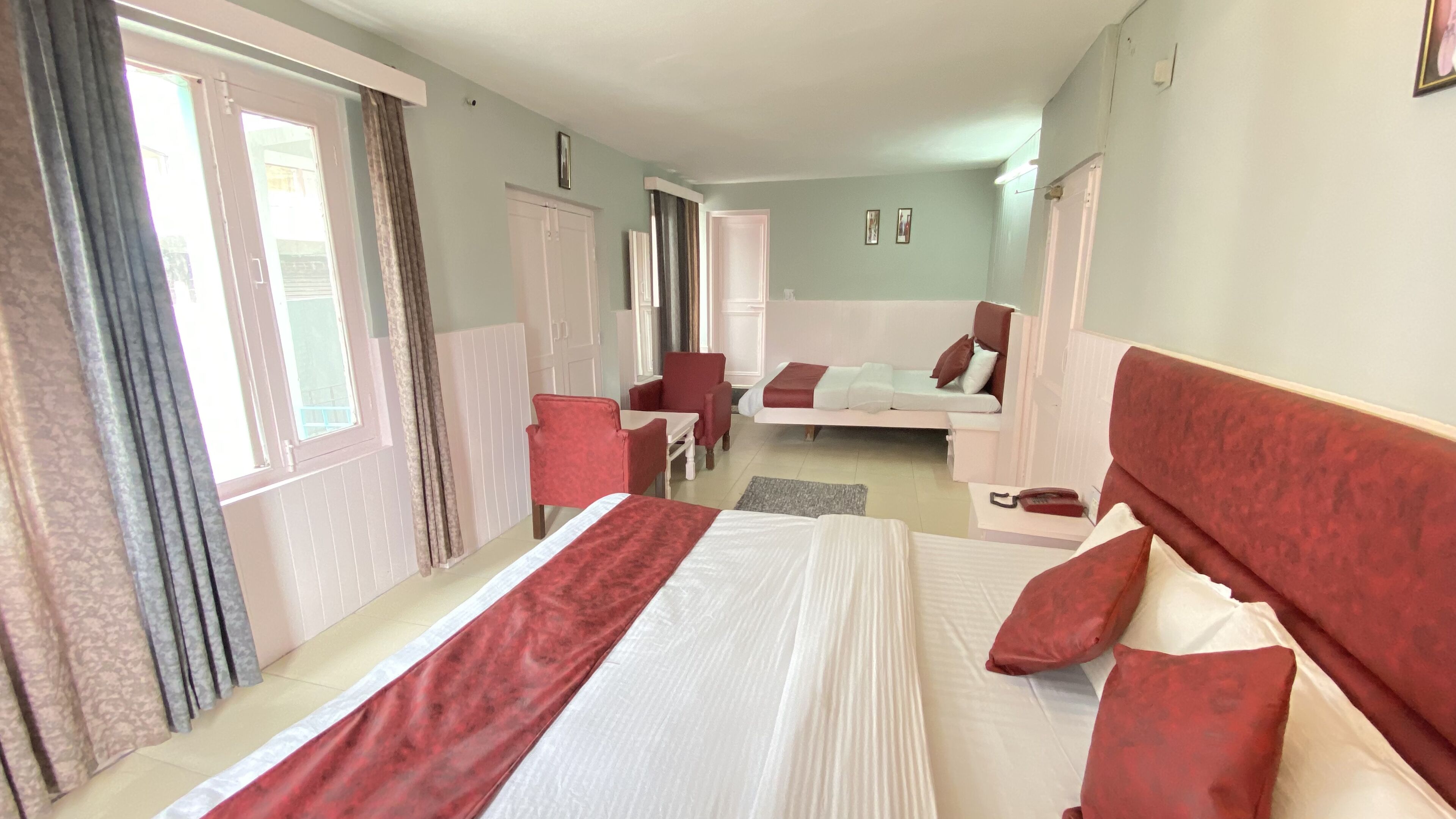 Ett hotellrum med en stor säng, en soffa, en fåtölj och ett litet bord.