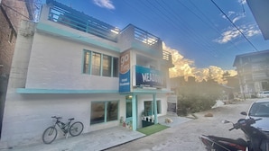 A two-story building with a sign for 'Hotel Meadows' and a 'go stays' sign. - Hotel Meadows (Manali)