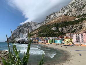 A coastal town with colorful buildings, a beach, and rocky cliffs. - Best views in Gibraltar, everything within walking distance. (Gibraltar)