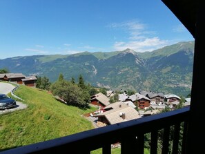 A mountain village with houses and a road curving through the landscape.