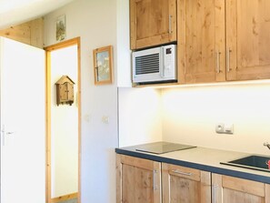 A kitchen with wooden cabinets, a built-in microwave, and a black countertop.