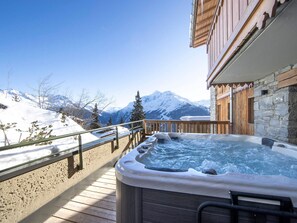 A hot tub on a wooden deck with a mountain view. - Chalet-style apartment with jacuzzi and parking in La Rosière center (Montvalezan-La Rosière)