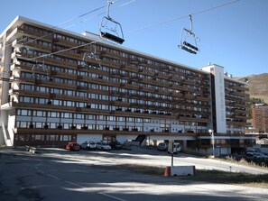 A large hotel with multiple floors, a parking lot, and a ski lift. - Renovated studio, direct access to slopes, balcony, all comfort (La Plagne)