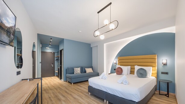 Une chambre à coucher moderne avec un lit, un bureau et un canapé.