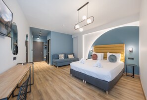 A modern bedroom with a bed, a desk, and a sofa. - Centro Urban Stay (Ioannina)