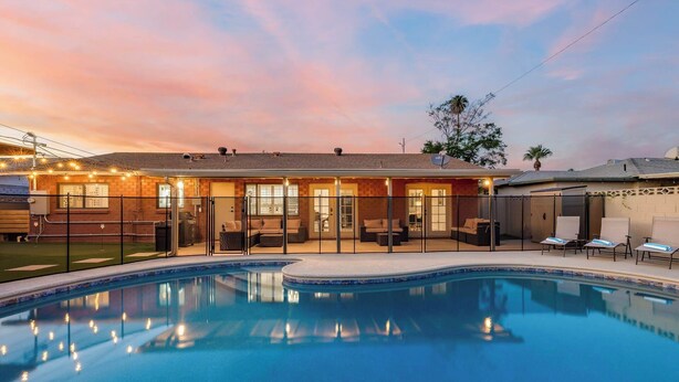 A residential property with a swimming pool, outdoor seating, and a brick house. - LUX w/Guest House, Pool, Putt, Mins to Old Town (Scottsdale)