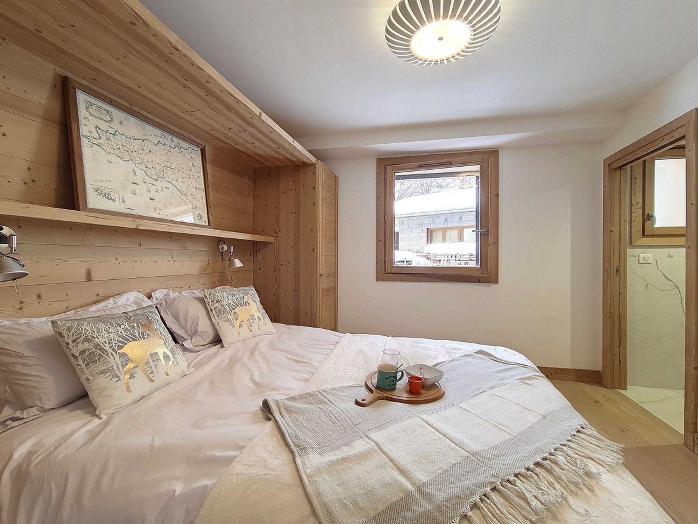 Una camera da letto con un letto, una mappa appesa al muro, una finestra e una porta.