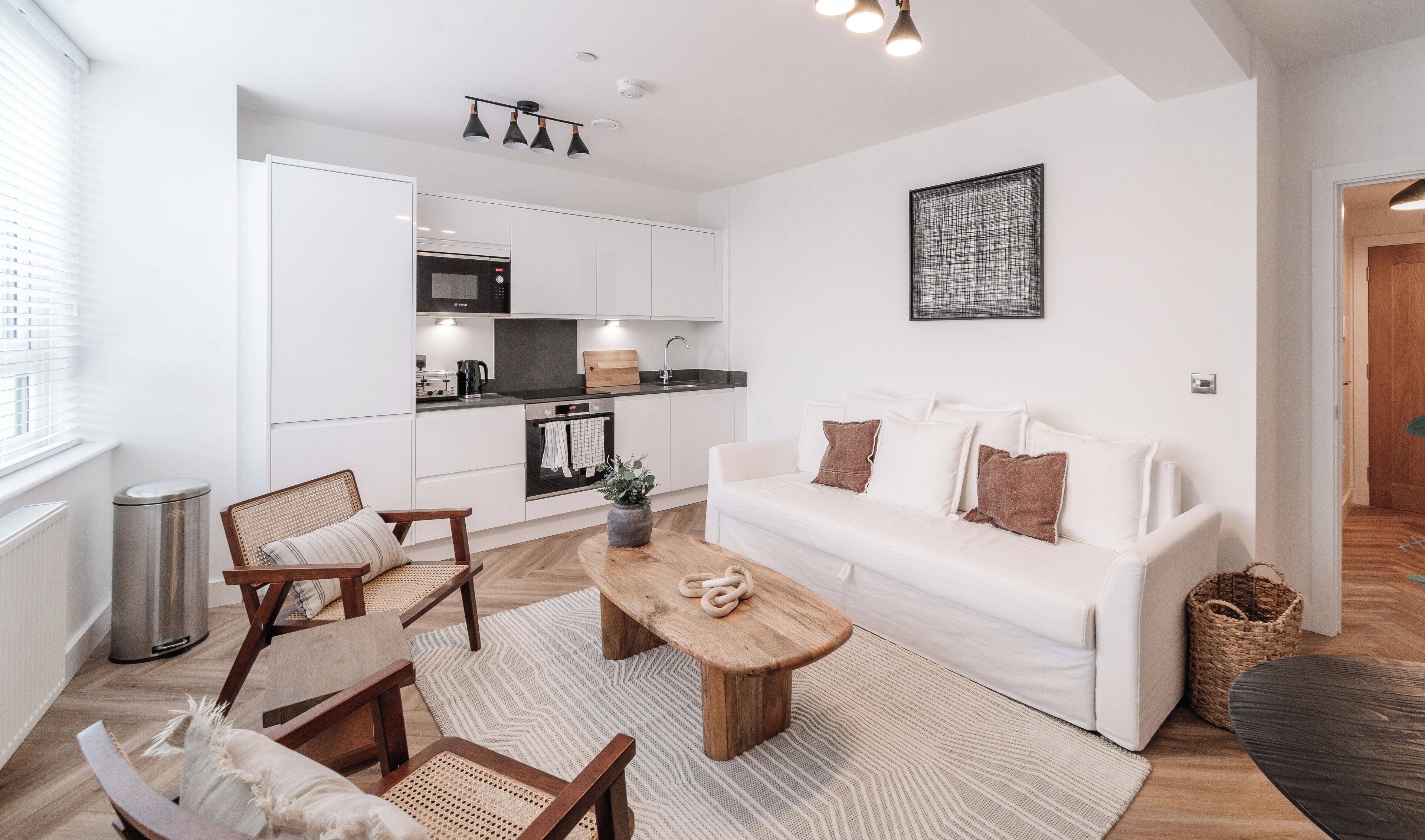 A modern apartment with a kitchen, living area, and a dining space.