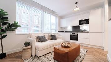 A modern living room with a sofa, a coffee table, and a potted plant.